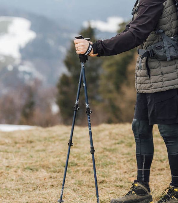 man som står med Alpine Explorer stavar